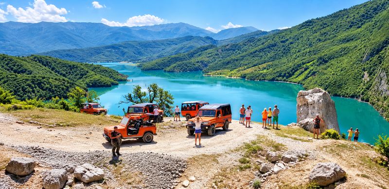 Off Limits jeep safari: orange 4x4 jeeps at the viewpoint above the turquoise Bovilla Lake near Tirana, Albania