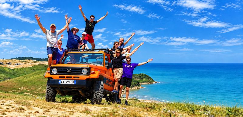 Happy group on an Off Limits jeep on the cliffs of the Cape of Rodon above the Adriatic Sea