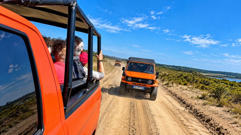 View from inside an open Off Limits jeep following another 4x4 on a dusty off-road track